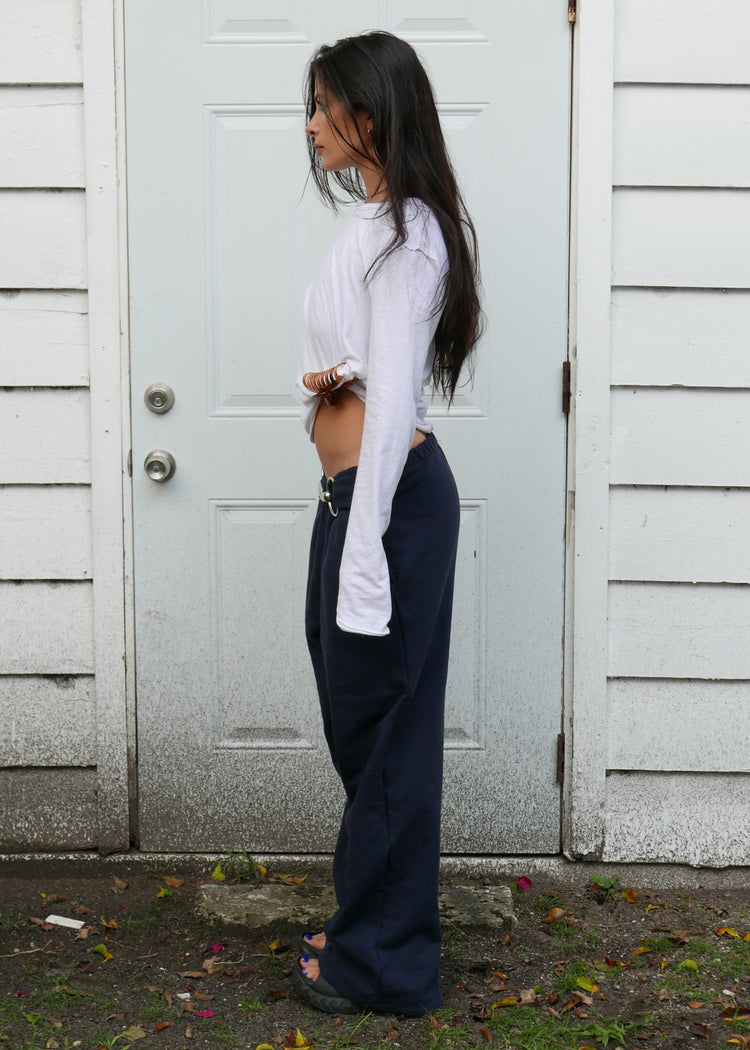 Model wearing midnight pants from the side in front of a door