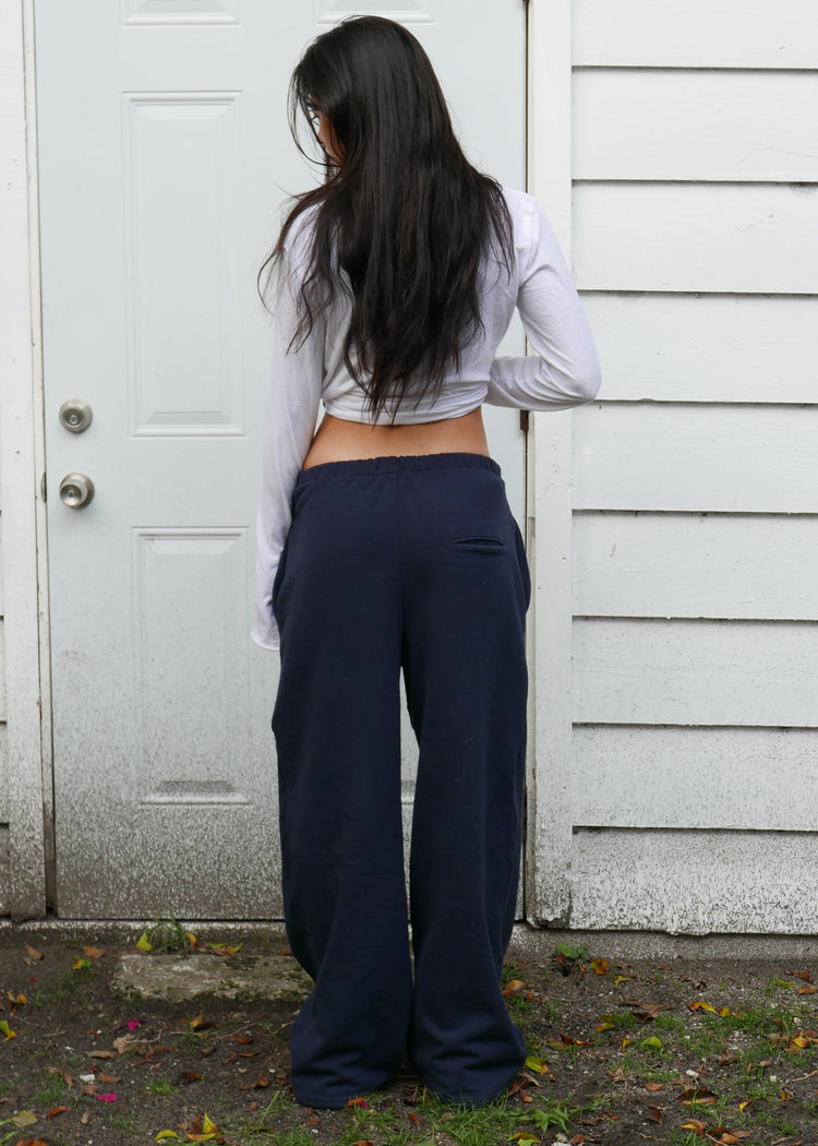 Model wearing midnight pants from behind in front of a door